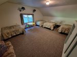 Large upstairs bedroom with 4 twin beds, sofa and play table.